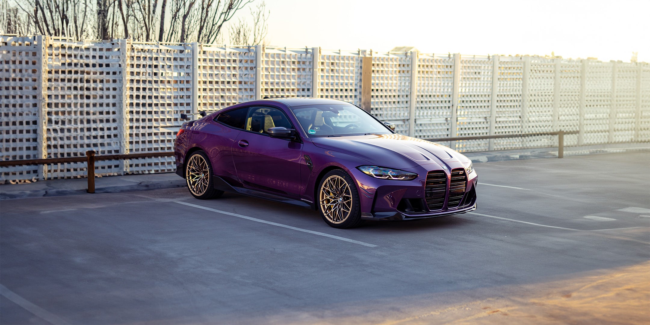 Purple BMW car on a rooftop with cityscape background