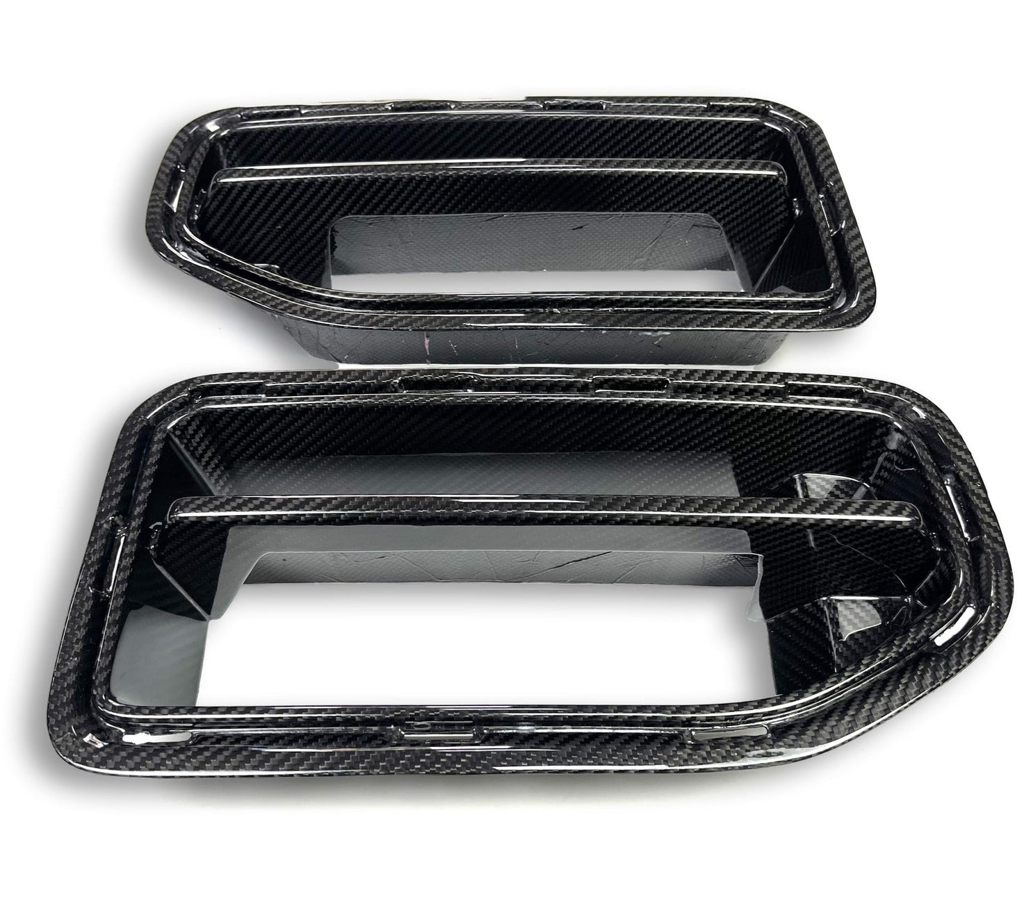 Close-up view of a WSTN Performance carbon fiber front grille designed for a BMW G87 M2, showcasing its intricate weave pattern and glossy finish.