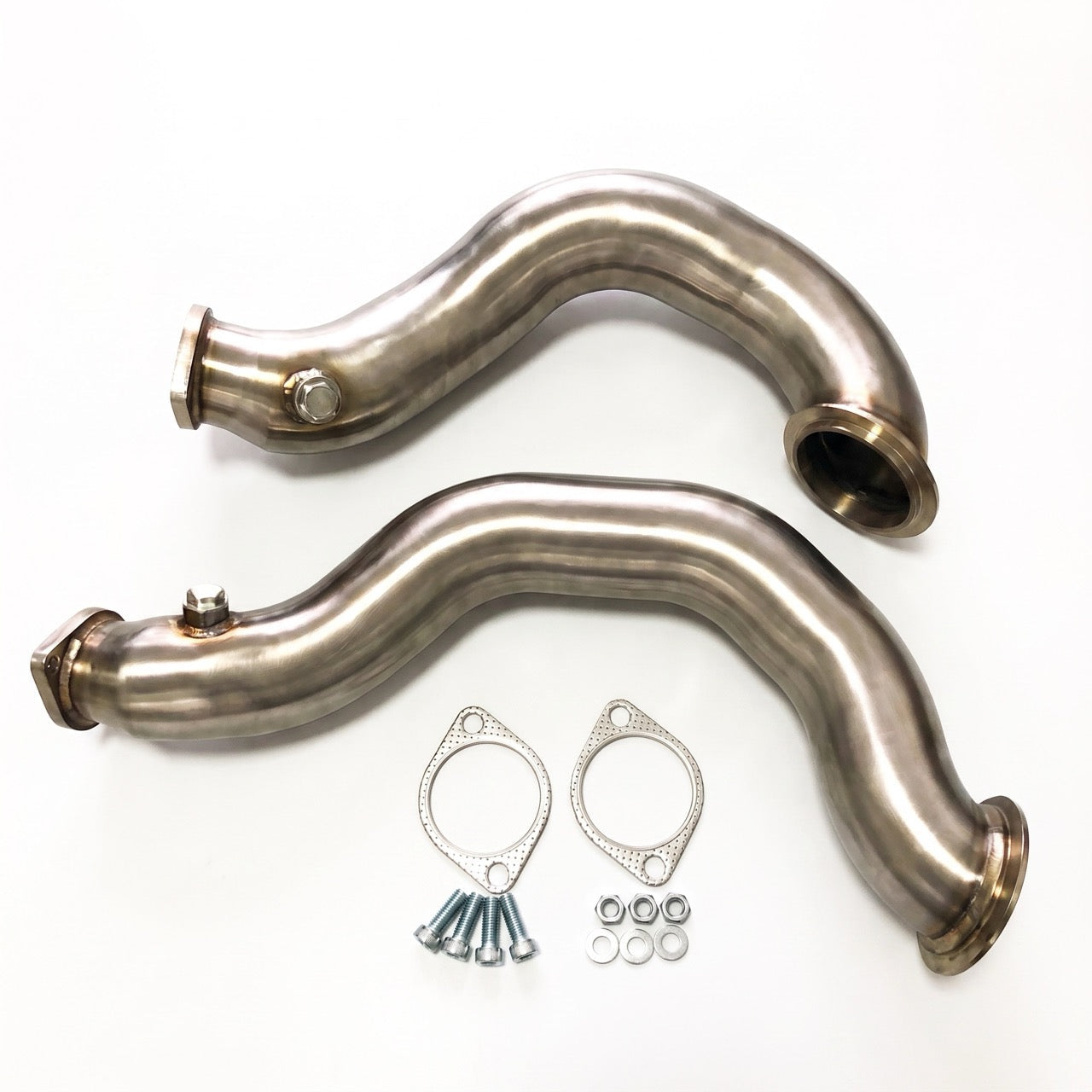 Two curved stainless steel exhaust manifolds with mounting gaskets, bolts, and washers, displayed on a clean white background.
