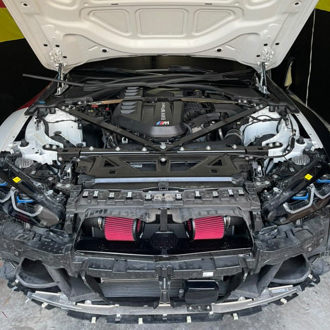 Car engine compartment with open hood showing mechanical components.